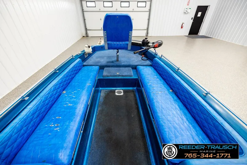 Slide: The Image of 1980 Ranger 175 VS boat interior with blue seating and motor, in a garage setting. - 13