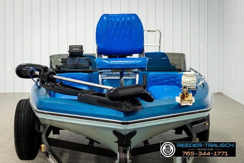Slide: The Image of 1980 Ranger 175 VS boat with blue seats and fishing equipment in a showroom. - 6