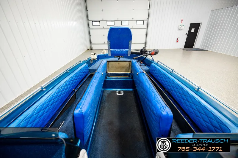 Slide: The Image of 1980 Ranger 175 VS boat interior with blue seating, displayed in a showroom. - 21