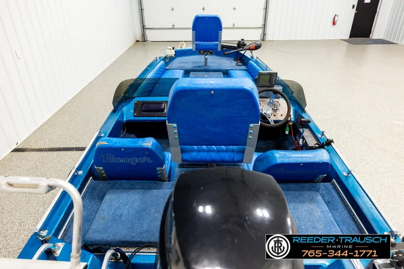 Slide: The Image of 1980 Ranger 175 VS boat interior with blue seats and steering wheel in a garage. - 11