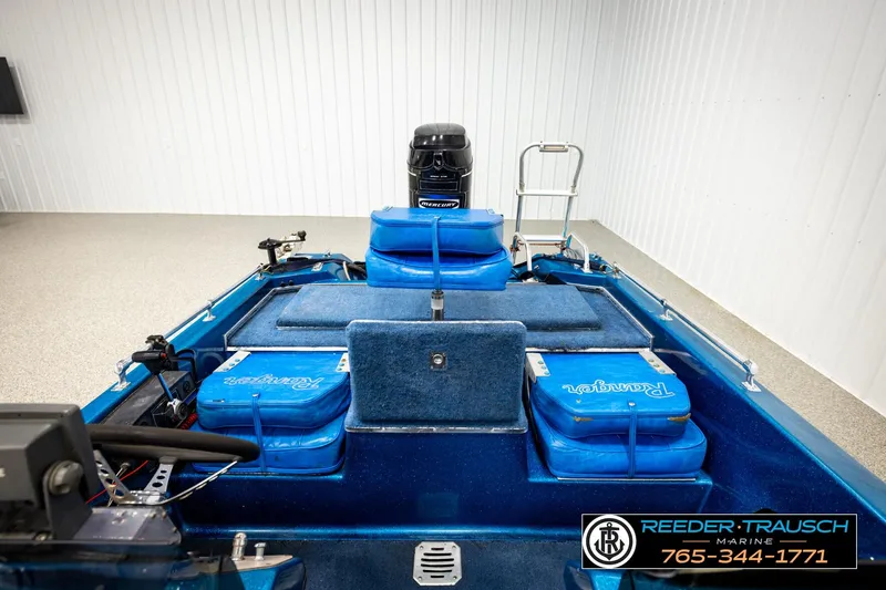 Slide: The Image of 1980 Ranger 175 VS boat interior with blue seating and motor, displayed indoors. - 18