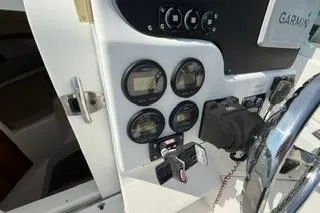 Slide: The Image of 2003 Edgewater 265 Express boat dashboard with gauges and Garmin equipment. - 20