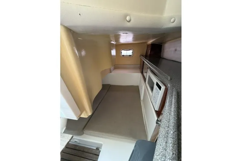 Slide: The Image of 2003 Edgewater 265 Express cabin interior with bed, window, and kitchenette. - 12