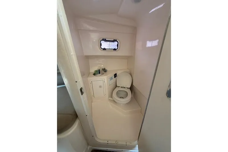 Slide: The Image of 2003 Edgewater 265 Express boat bathroom with toilet and small window. - 15