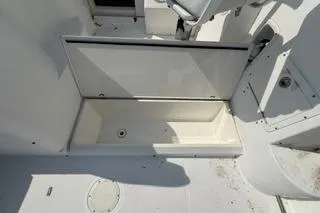 Slide: The Image of 2003 Edgewater 265 Express boat storage compartment, open and empty, with clean white interior. - 18