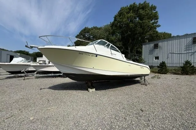 The Image of 2003 Edgewater 265 Express boat on gravel lot, sunny day, trees and building in background. - 1