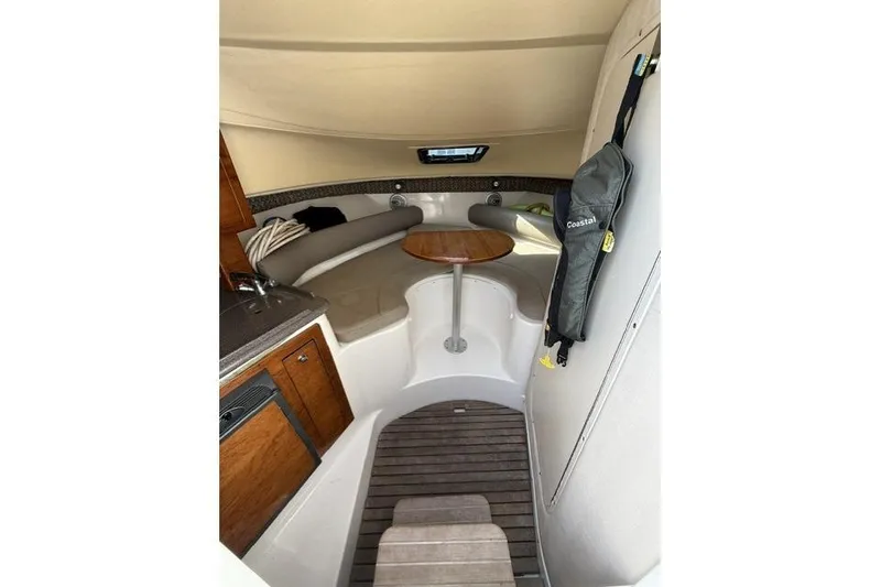 Slide: The Image of Interior of a 2003 Edgewater 265 Express boat with seating and wooden table. - 10