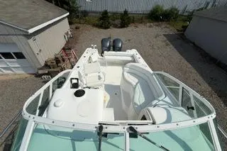 Slide: The Image of 2003 Edgewater 265 Express boat with dual engines, docked in a gravel yard. - 27