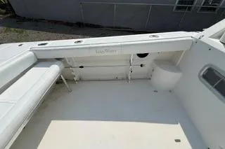 Slide: The Image of 2003 Edgewater 265 Express boat interior with white seating and storage compartments. - 29