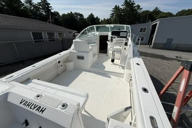 Slide: The Image of 2003 Edgewater 265 Express boat with spacious deck and seating, parked outdoors. - 6