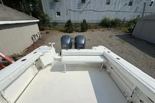 Slide: The Image of 2003 Edgewater 265 Express boat with dual outboard motors in a yard setting. - 17