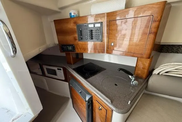 Slide: The Image of Interior of 2003 Edgewater 265 Express boat with kitchenette and wooden cabinetry. - 11