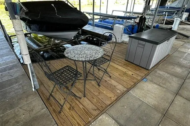 Slide: The Image of Covered 2007 Four Winns 200 Horizon boat docked beside a patio set on wooden deck. - 22