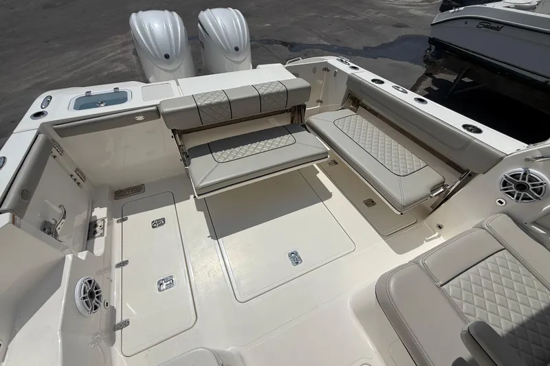 Slide: The Image of 2024 Pursuit DC 306 Dual Console boat interior with cushioned seating and twin engines. - 12