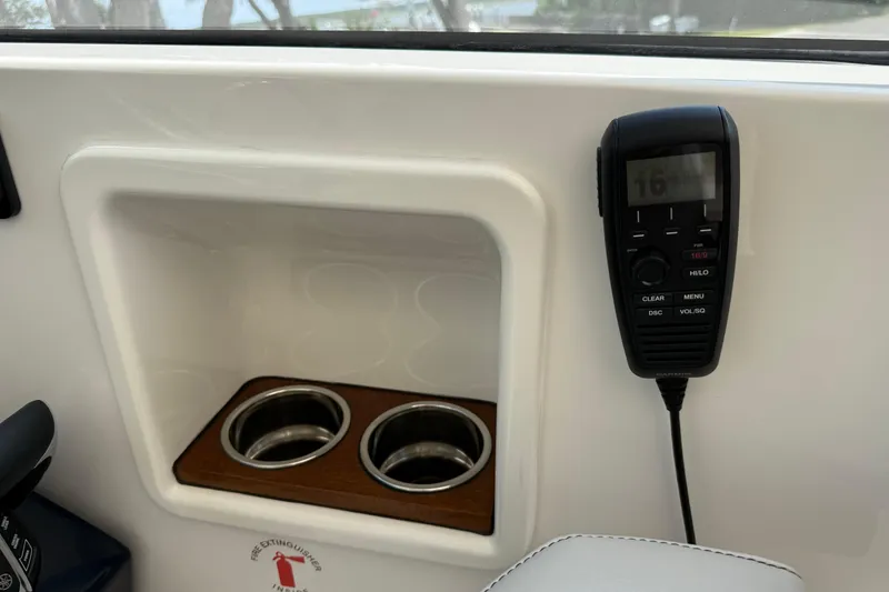 Slide: The Image of 2024 Pursuit DC 306 Dual Console interior with cup holders and radio. - 28