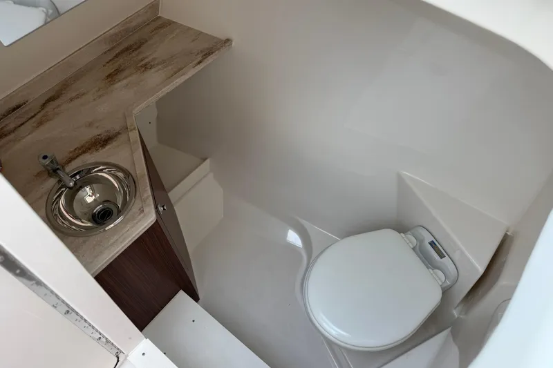 Slide: The Image of 2024 Pursuit DC 306 Dual Console boat bathroom with sink and toilet. - 31