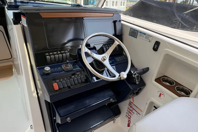 Slide: The Image of 2024 Pursuit DC 306 Dual Console helm with modern controls and steering wheel. - 23