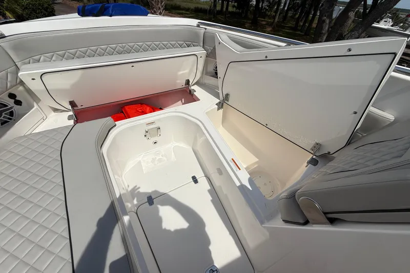 Slide: The Image of 2024 Pursuit DC 306 Dual Console boat with open storage compartments and quilted seating. - 38