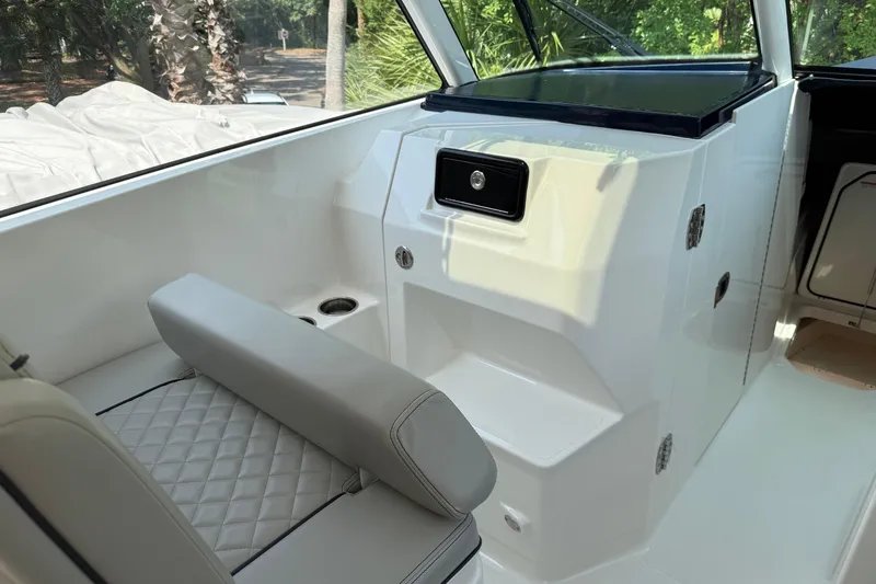 Slide: The Image of 2024 Pursuit DC 306 Dual Console interior with cushioned seating and storage compartment. - 21