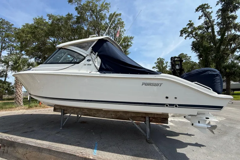 Slide: The Image of 2024 Pursuit DC 306 Dual Console boat on display, featuring sleek design and covered seating. - 2