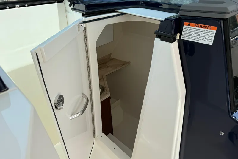 Slide: The Image of 2024 Pursuit DC 306 Dual Console boat interior with open storage compartment. - 30