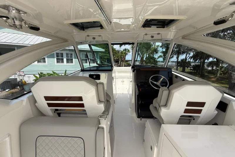 Slide: The Image of 2024 Pursuit DC 306 Dual Console interior with modern helm and seating. - 19