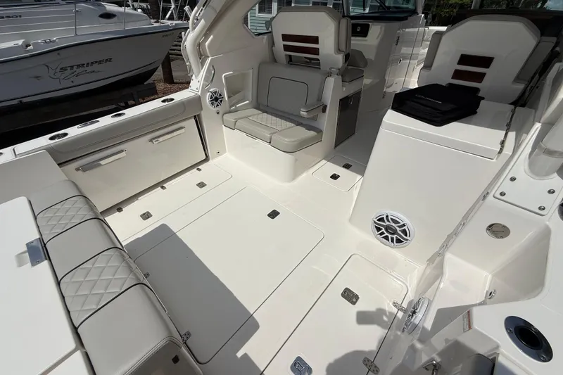 Slide: The Image of 2024 Pursuit DC 306 Dual Console boat interior with seating and storage compartments. - 13