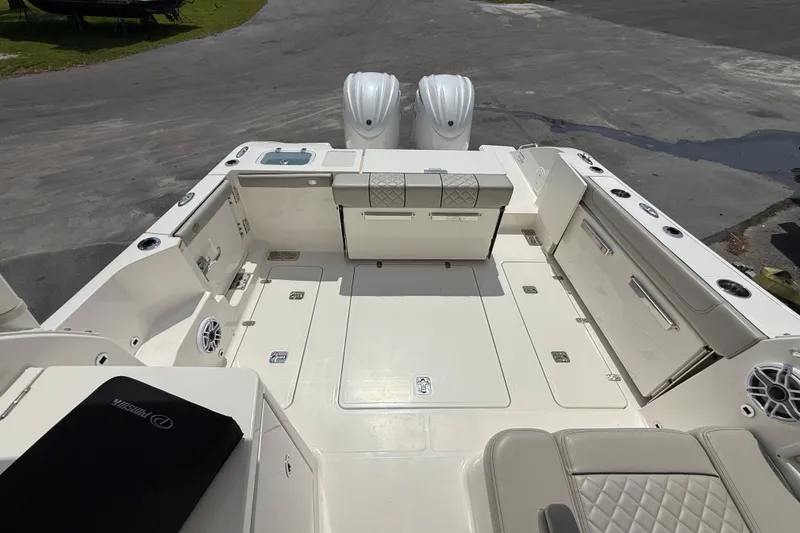 Slide: The Image of 2024 Pursuit DC 306 Dual Console boat deck with seating and storage compartments. - 10