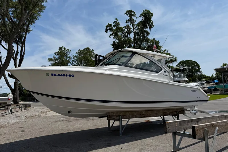 Slide: The Image of 2024 Pursuit DC 306 Dual Console boat on display outdoors. - 9