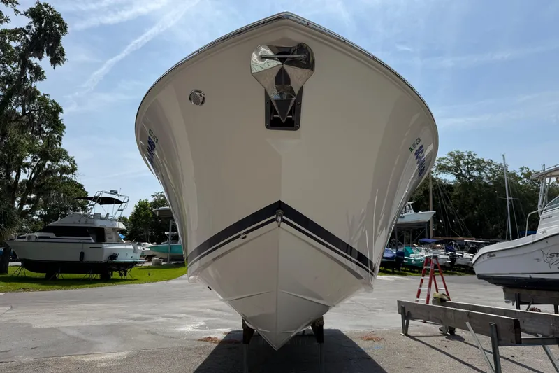 Slide: The Image of 2024 Pursuit DC 306 Dual Console boat on display at a marina. - 7