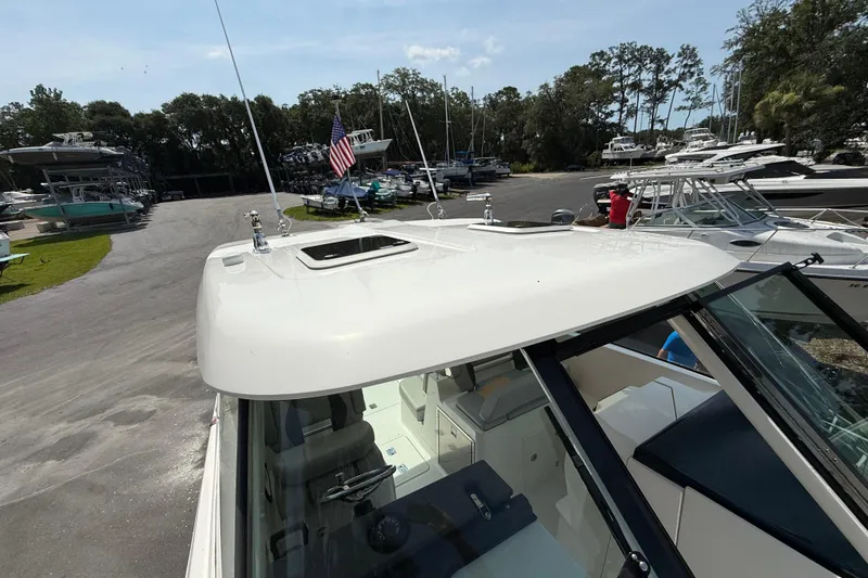 Slide: The Image of 2024 Pursuit DC 306 Dual Console boat at marina, showcasing sleek design and spacious interior. - 45