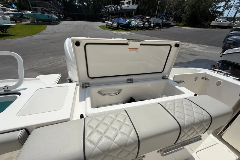Slide: The Image of 2024 Pursuit DC 306 Dual Console boat with open storage compartment and cushioned seating. - 14