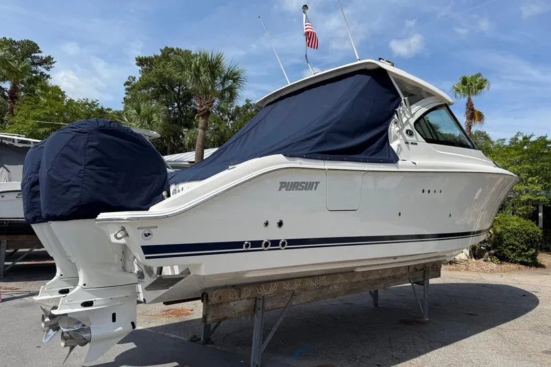 Slide: The Image of 2024 Pursuit DC 306 Dual Console boat on display with covered engines. - 4
