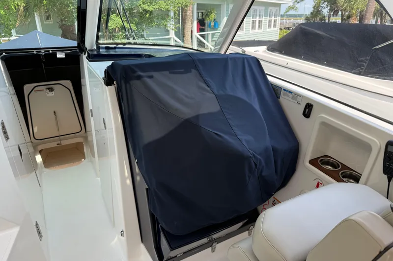 Slide: The Image of 2024 Pursuit DC 306 Dual Console interior with covered seating and storage compartments. - 18