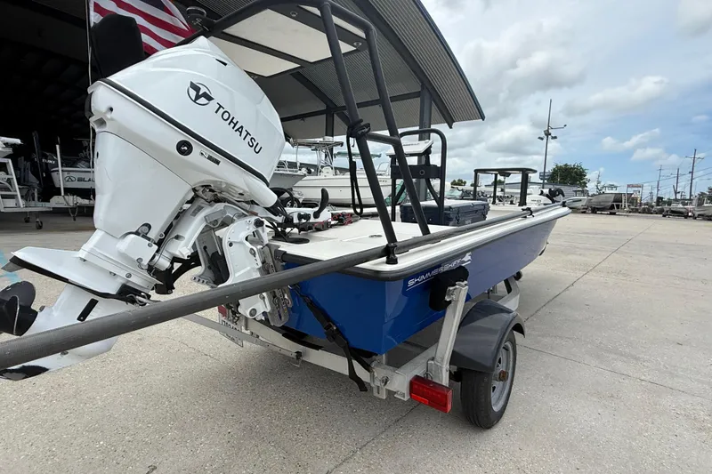 Slide: The Image of 2020 Skimmer Skiff 14 boat with Tohatsu engine on a trailer, parked outdoors. - 2