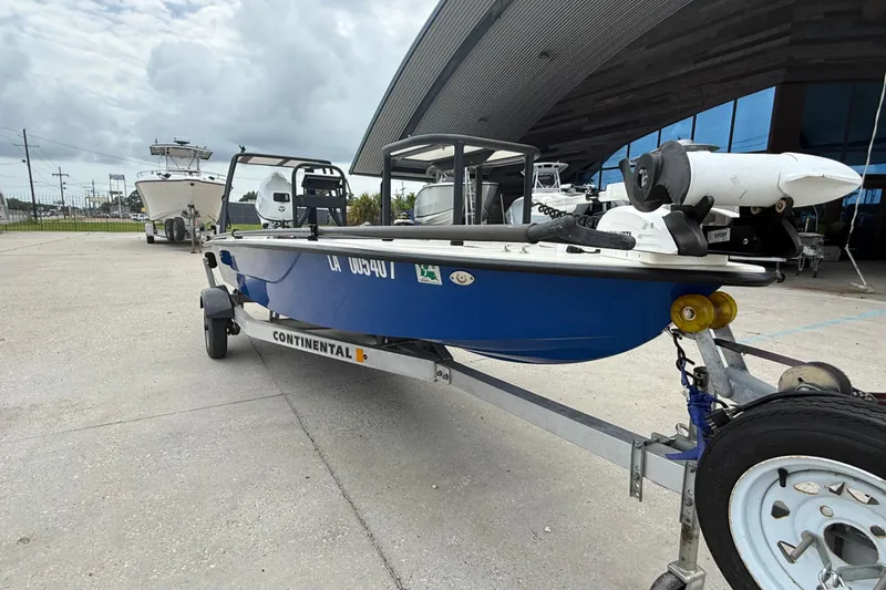 Slide: The Image of 2020 Skimmer Skiff 14 boat on trailer, parked outside a modern building. - 3