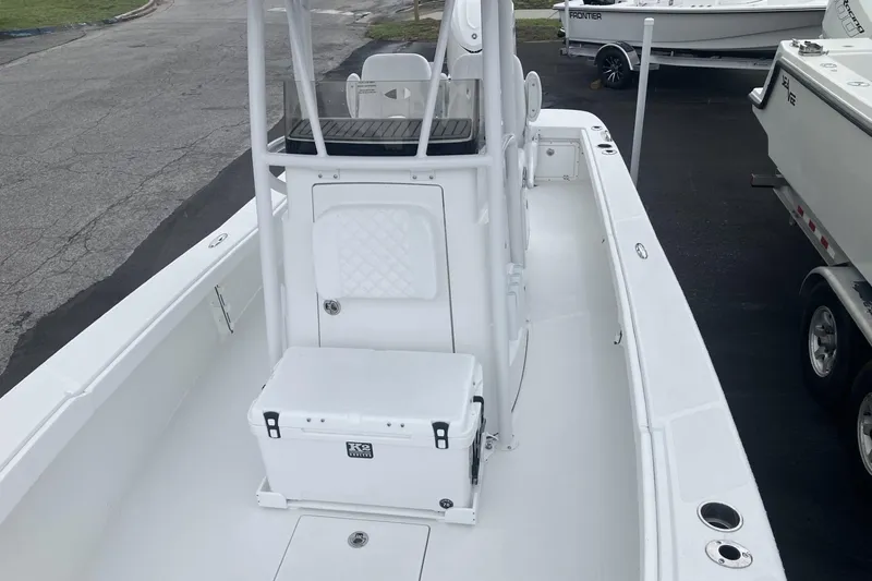 Slide: The Image of 2026 BlackJack 256 Coastal boat interior with console and seating, parked on pavement. - 13