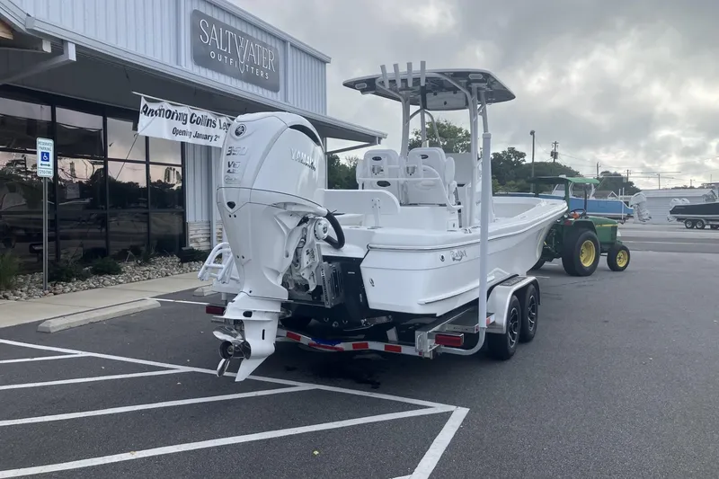 Slide: The Image of 2026 BlackJack 256 Coastal boat on trailer outside Saltwater Outfitters store. - 7
