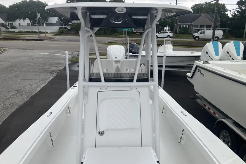 Slide: The Image of 2026 BlackJack 256 Coastal boat, white exterior, parked on a trailer in a lot. - 15