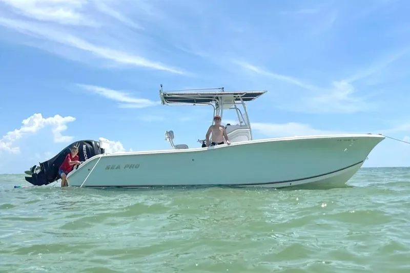 The Image of A 2007 Sea Pro 270 Center Console boat floats on calm water under a blue sky. - 0