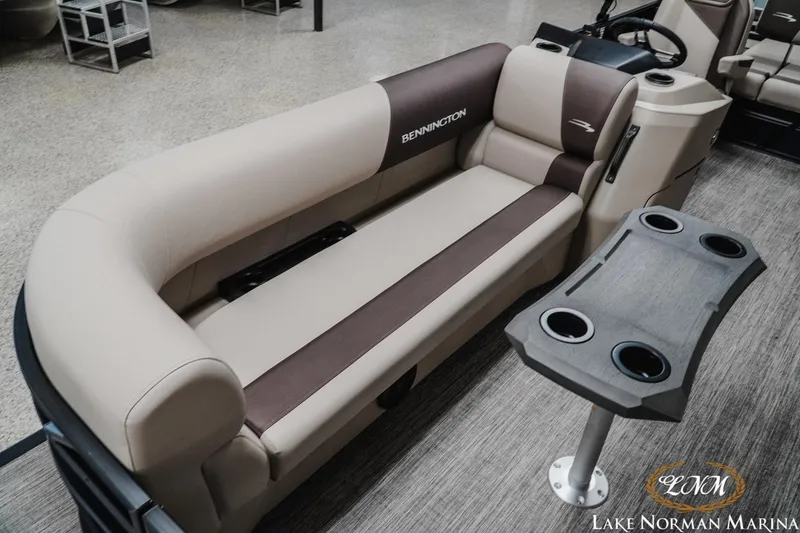 Slide: The Image of 2026 Bennington 22SSB pontoon boat interior with beige seating and cup holder table. - 10