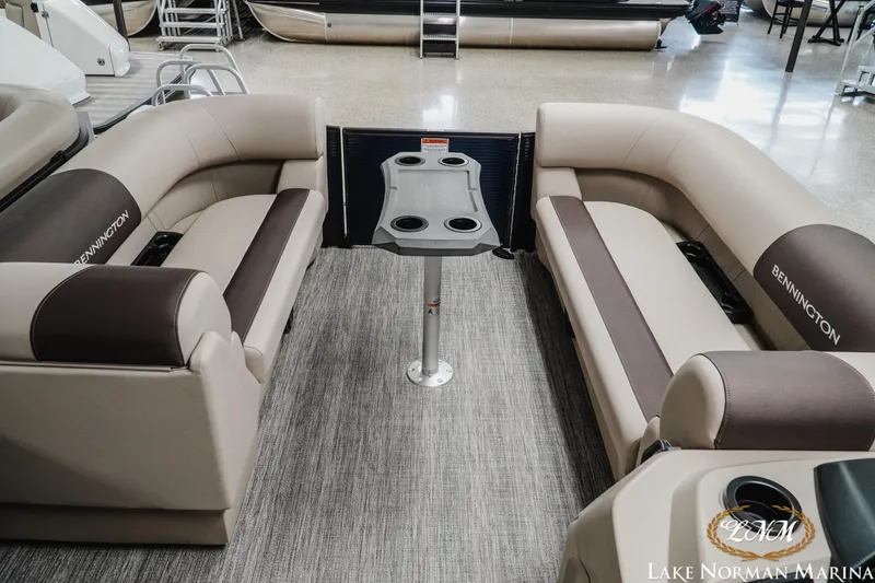 Slide: The Image of 2026 Bennington 22SSB pontoon boat interior with plush seating and table at Lake Norman Marina. - 7