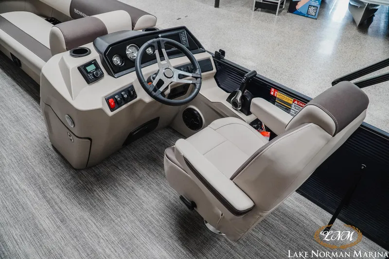 Slide: The Image of 2026 Bennington 22SSB boat interior with steering console and seating at Lake Norman Marina. - 5