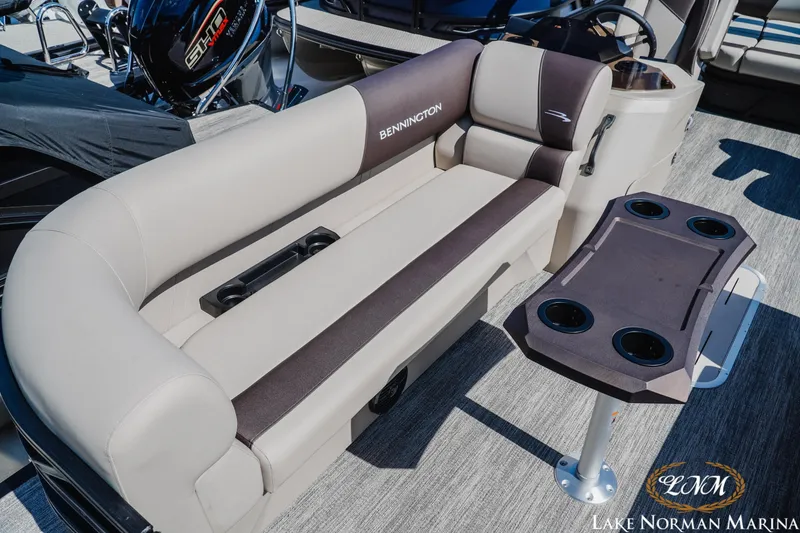Slide: The Image of 2027 Bennington 23SSB pontoon boat interior with plush seating and cupholder table at Lake Norman Marina. - 16