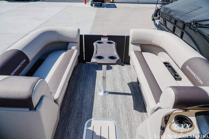 Slide: The Image of 2027 Bennington 23SSB pontoon boat interior with plush seating and central table. - 13
