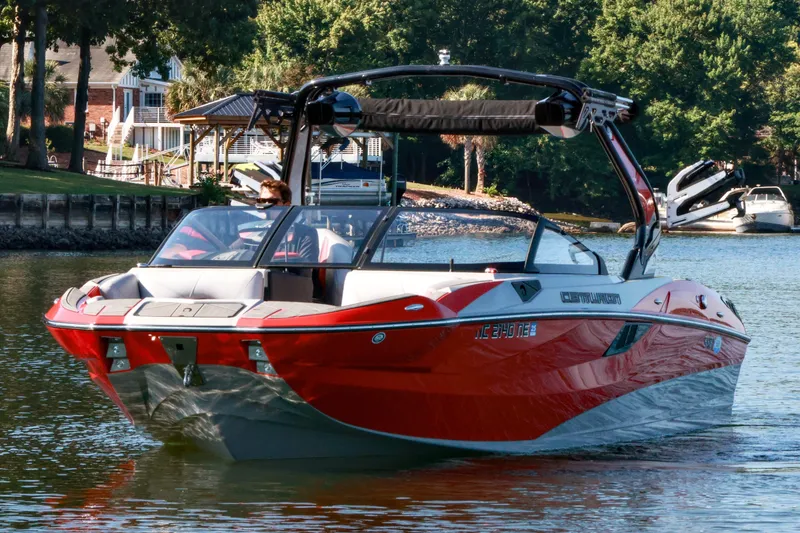 Slide: The Image of 2024 Centurion Fi23 boat cruising on a scenic lake with lush greenery. - 4