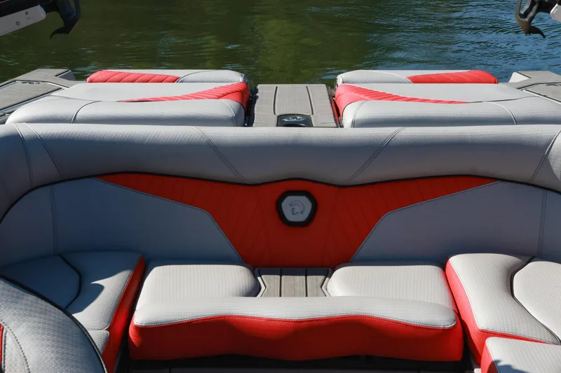 Slide: The Image of 2024 Centurion Fi23 boat interior with red and gray seating, on calm water. - 15