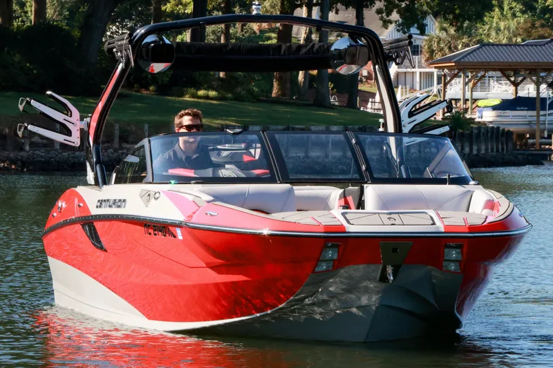 Slide: The Image of 2024 Centurion Fi23 boat in vibrant red on a serene lake. - 2