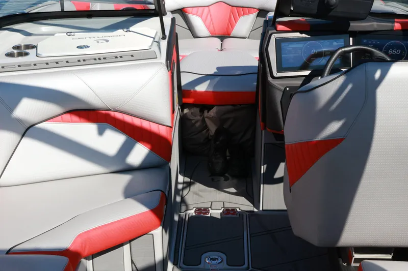 Slide: The Image of 2024 Centurion Fi23 boat interior with red and gray seating, modern dashboard, and steering wheel. - 10