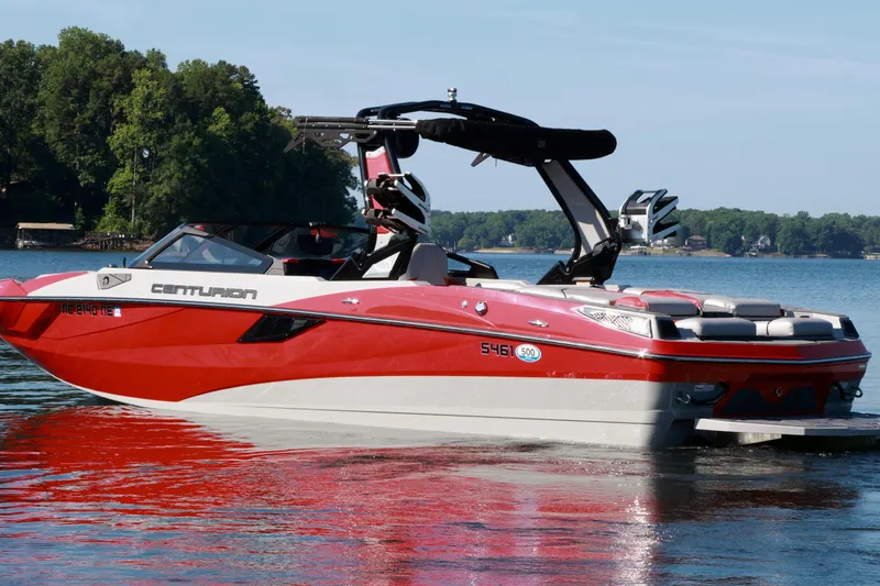 Slide: The Image of 2024 Centurion Fi23 boat in red and white on a serene lake. - 7